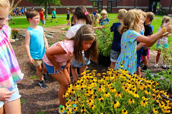 students in a flower garden with butterflies